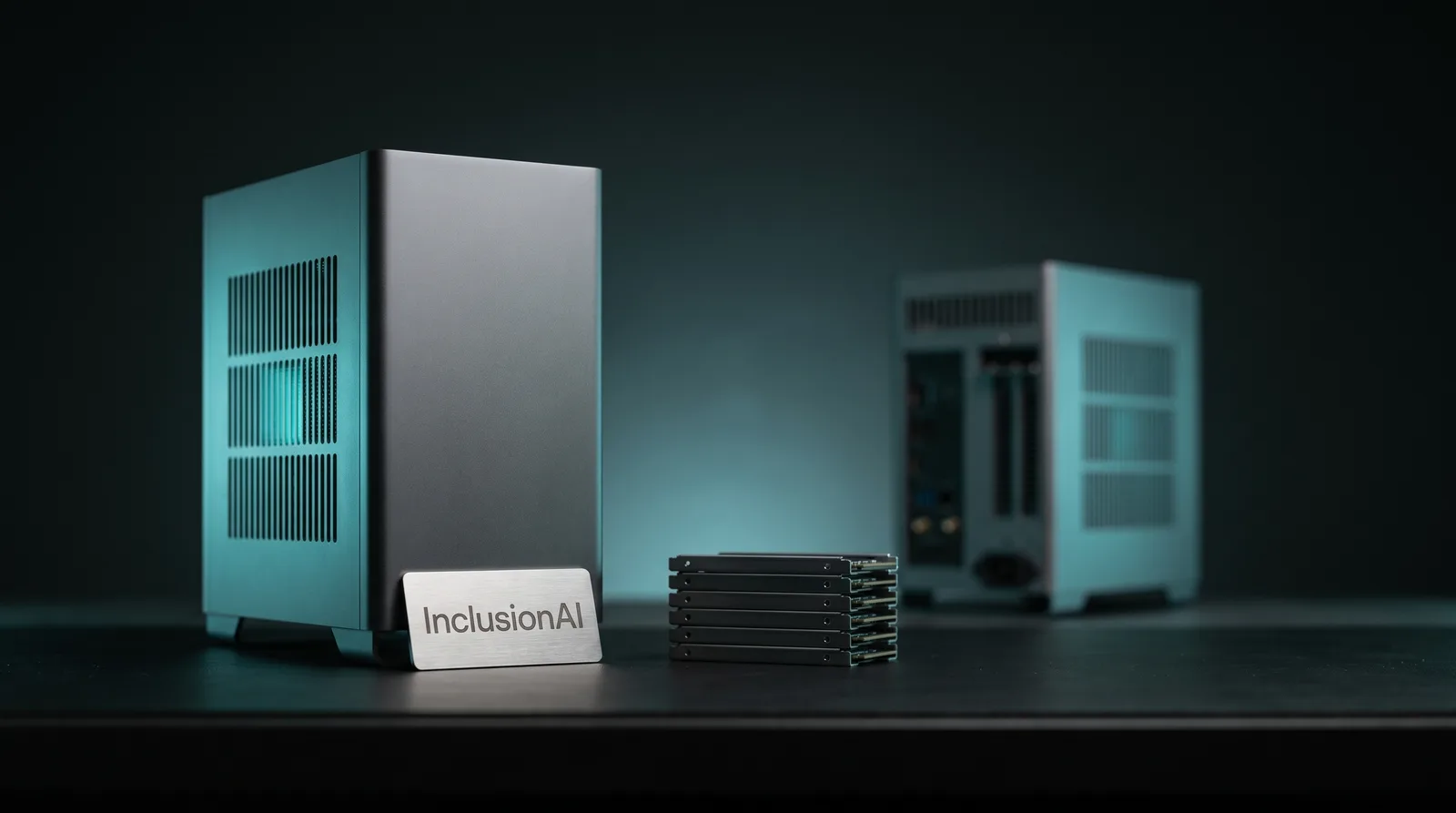 A compact aluminium desktop workstation on a dark studio bench with a vendor wordmark plaque and bare NVMe drive sleds beside it, lit by cyan-teal accent light.