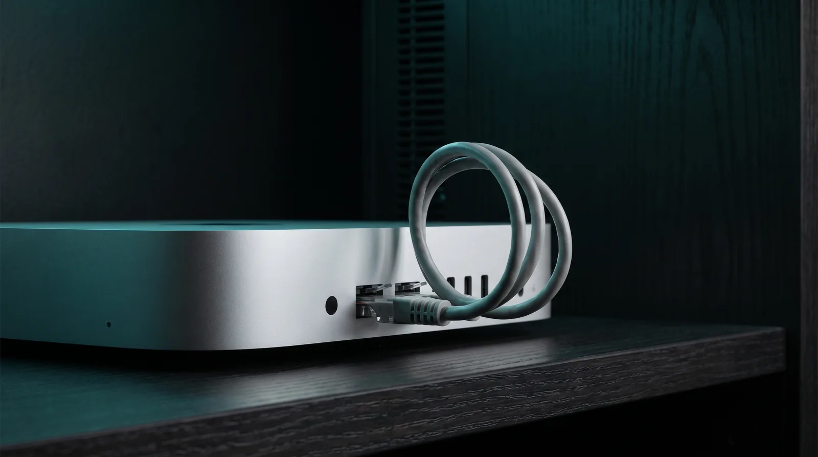 A compact desktop computer with an ethernet cable looping back into its own chassis, symbolizing a local model endpoint bound to loopback only.
